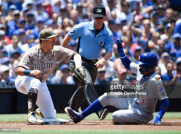 Javier Baez of the Chicago Cubs slides into third base ahead of the throw to Christian Villanueva of the San Diego Padres during the first inning of...