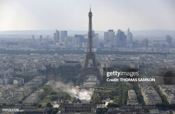 This picture taken from the panoramic observatory of the Montparnasse Tower shows people reacting in the fan zone on the Champs de Mars near the...