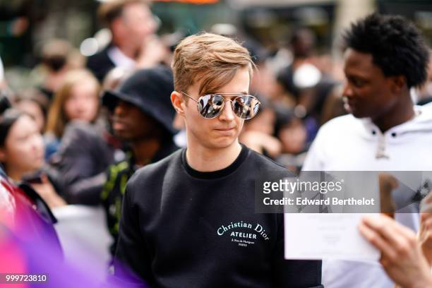 Guest wears silver sunglasses and a "atelier" Christian Dior black pullover, outside Dior, during Paris Fashion Week - Menswear Spring-Summer 2019,...