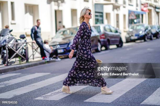 Guest wears a flower print dress, white shoes, outside Wooyoungmi, during Paris Fashion Week - Menswear Spring-Summer 2019, on June 23, 2018 in...