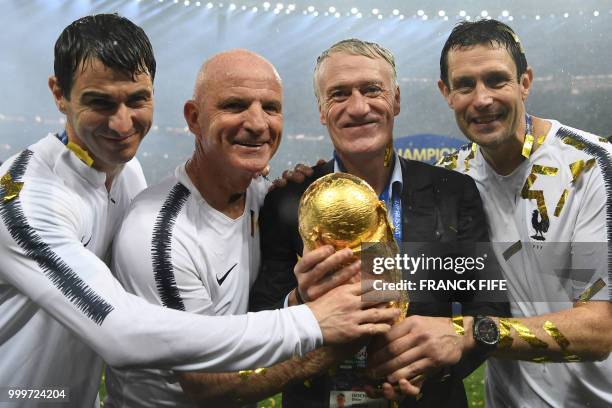 France's coach Didier Deschamps and France's assistant coach Guy Stephan pose with the World Cup trophy after the Russia 2018 World Cup final...