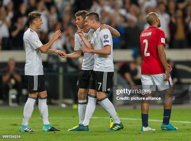 Germany's Mesut Oezil and Thomas Mueller congratulate Julian Draxler who scored the 2:0 during the soccer World Cup qualification group stage match...