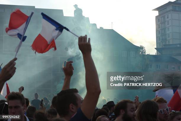 People wave French flags during the Russia 2018 World Cup final football match between France and Croatia, on July 15, 2018 in Strasbourg, eastern...