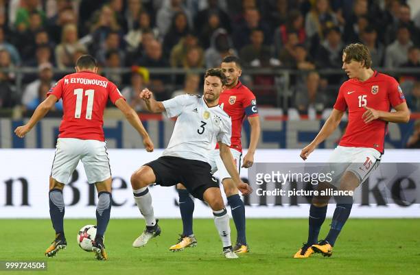 Germany's Jonas Hector and Norway's Mohamed Elyounoussi and Sander Berge vie for the ball during the soccer World Cup qualification group stage match...
