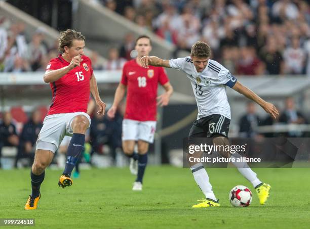 Germany's Thomas Mueller and Norway's Omar Elabdellaoui fight for the ball while Norway's Sander Berge watches, during the soccer World Cup...