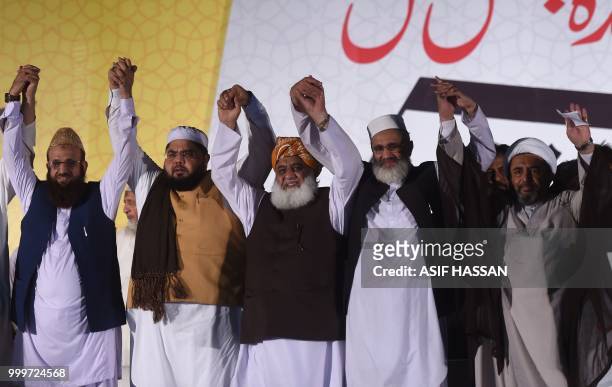 Leaders of Muttahida Majlis-e-Amal , a religious parties alliance, Maulana Fazlur Rehman, Siraj-ul-Haq and others raise hands during an election...