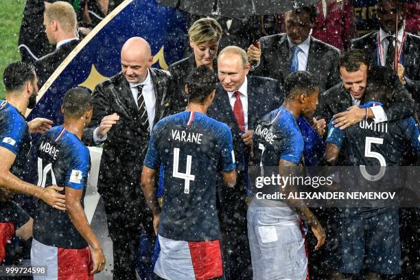 France's defender Raphael Varane is congratulated by Russian President Vladimir Putin during the trophy ceremony at the end of the Russia 2018 World...