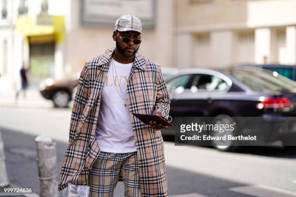 Guest wears a cap, a tartan checked jacket, outside Wooyoungmi, during Paris Fashion Week - Menswear Spring-Summer 2019, on June 23, 2018 in Paris,...