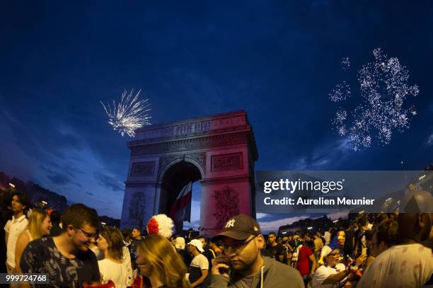 French fans gather on the Arc de Triomphe which has the French flag colours to celebrate the victory of France over Croatia 4-2 during the World Cup...