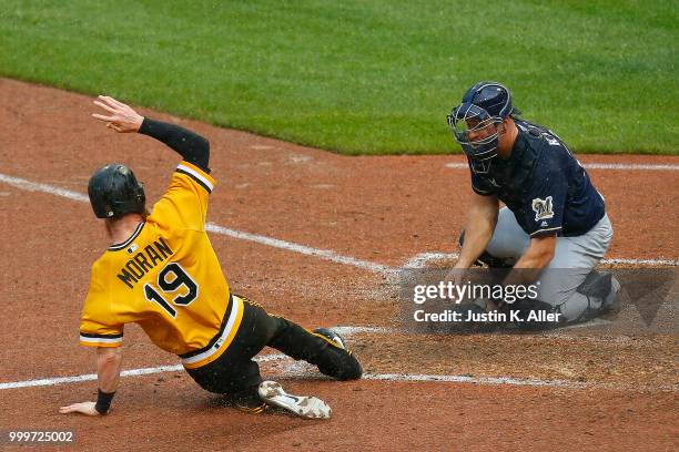 Colin Moran of the Pittsburgh Pirates slides in safe on a two RBI double in the nineteenth inning against Erik Kratz of the Milwaukee Brewers at PNC...