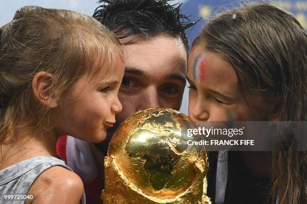 France's goalkeeper Hugo Lloris kisses the World Cup trophy between his daughters as he celebrates with teammates winning the Russia 2018 World Cup...