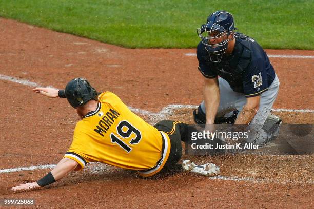 Colin Moran of the Pittsburgh Pirates slides in safe on a two RBI double in the nineteenth inning against Erik Kratz of the Milwaukee Brewers at PNC...