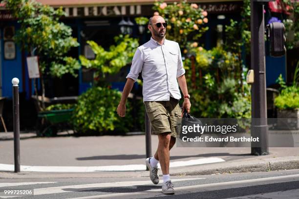 Guest wears a white shirt, green khaki shorts, white socks, sneakers shoes, outside Wooyoungmi, during Paris Fashion Week - Menswear Spring-Summer...