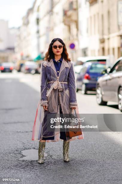 Guest wears a mesh trench coat, snake print boots, a brown bag, outside Wooyoungmi, during Paris Fashion Week - Menswear Spring-Summer 2019, on June...