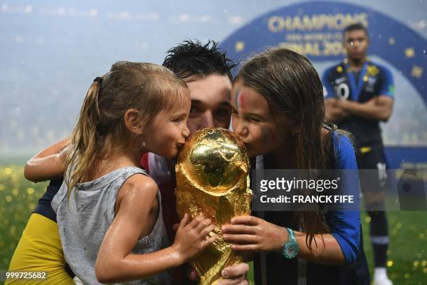 France's goalkeeper Hugo Lloris kisses the World Cup trophy between his daughters as he celebrates with teammates winning the Russia 2018 World Cup...