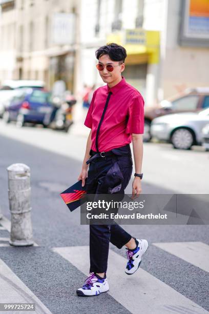 Guest wears a pink shirt, a black tie, a belt, black pants, sneakers, outside Wooyoungmi, during Paris Fashion Week - Menswear Spring-Summer 2019, on...