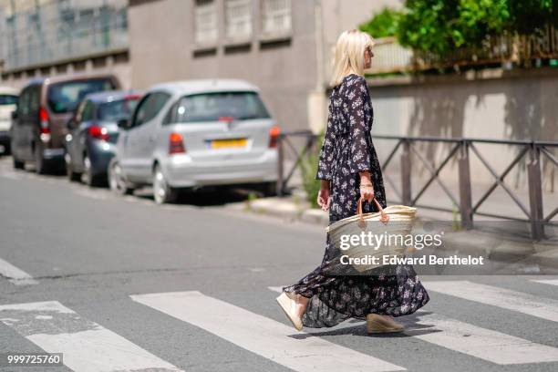 Guest wears a floral print dress, a basket bag, outside Wooyoungmi, during Paris Fashion Week - Menswear Spring-Summer 2019, on June 23, 2018 in...