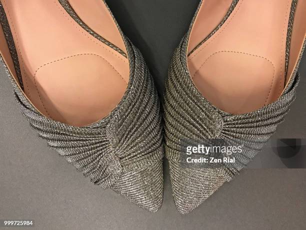 a pair of elegant metallic evening shoes on gray background - golden shoes stock pictures, royalty-free photos & images