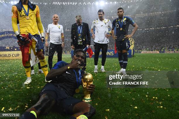France's defender Samuel Umtiti poses with the World Cup trophy after winning the Russia 2018 World Cup final football match between France and...