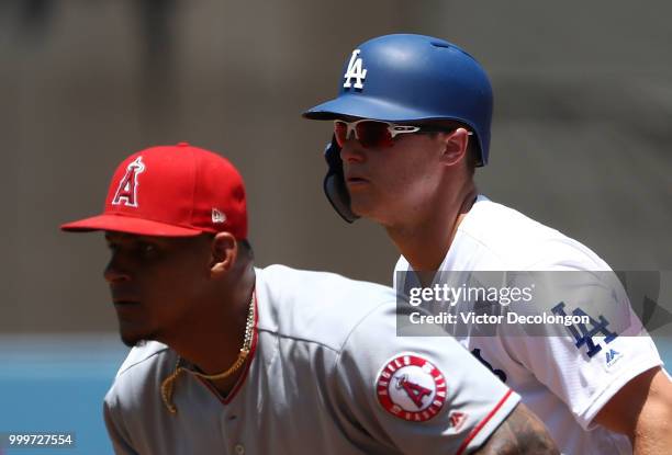 Joc Pederson of the Los Angeles Dodgers leads off as Jefry Marte of the Los Angeles Angels of Anaheim looks on from first base in the first inning...