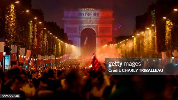 The Arch of Triumph is illuminated with the colours of France, as France supporters celebrate on the Champs-Elysees avenue in Paris on July 15 after...