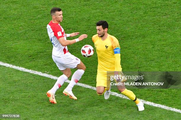 France's goalkeeper Hugo Lloris gets to the ball ahead of Croatia's forward Ivan Perisic during the Russia 2018 World Cup final football match...