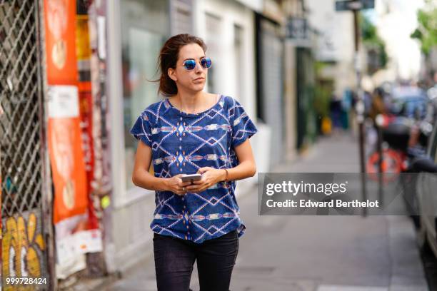 Guest wears blue sunglasses , a blue t-shirt with printed patterns, outside Yohji Yamamoto, during Paris Fashion Week - Menswear Spring-Summer 2019,...