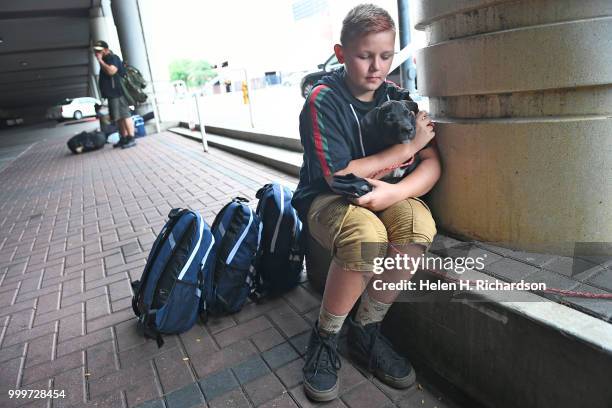 Shawn Kalloch holds onto his new puppy Dr. Pupper while he awaits veterinary care with his family during an on-site street clinic outside of the...