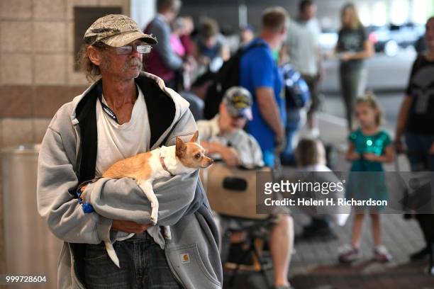 William Nicol, who has been homeless for over a year, holds his chihuahua Tinkerbell while they await veterinary during an on-site street clinic...