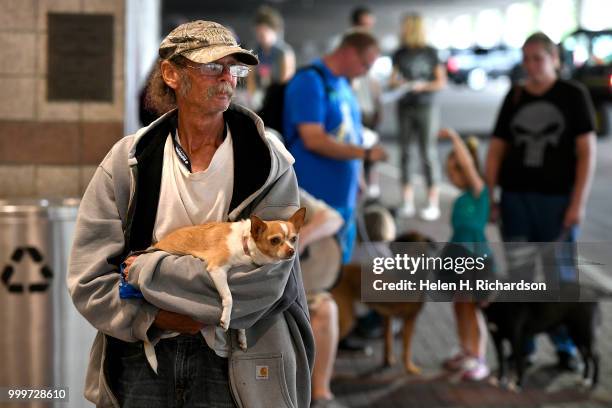 William Nicol, who has been homeless for over a year, holds his chihuahua Tinkerbell while they await veterinary during an on-site street clinic...