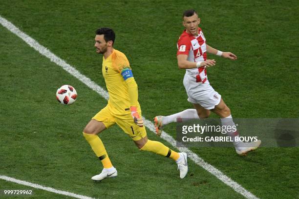 France's goalkeeper Hugo Lloris controls the ball ahead of Croatia's forward Ivan Perisic during the Russia 2018 World Cup final football match...