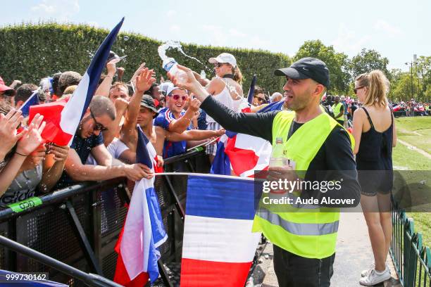 Security throw water to fans because of the heat during the FIFA World Cup final match between France and Croatia at Fan Zone at Champ de Mars on...