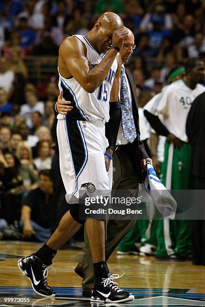 Vince Carter of the Orlando Magic walks toward the bench in pain as he is attended to by a member of the medical staff against the Boston Celtics in...