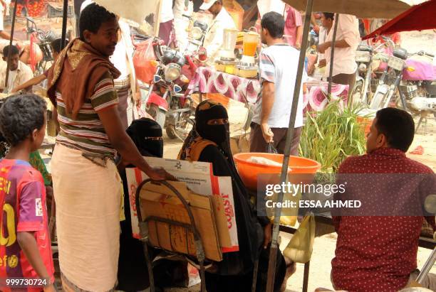 Yemeni women sell their products at a market in Hajjah province's northern district of Abs on July 15, 2018.