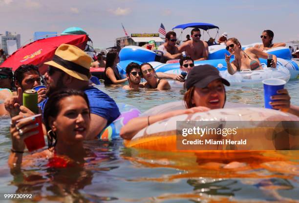 Young couple keeps cool and close as they and thousands of soccer fans cool off in the water while attending the "Ballyhoo Boat Bash" at the Haulover...