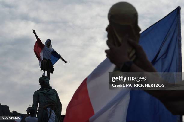 Peopler wave French national flags as they celebrate after France won the Russia 2018 World Cup final football match between France and Croatia, on...