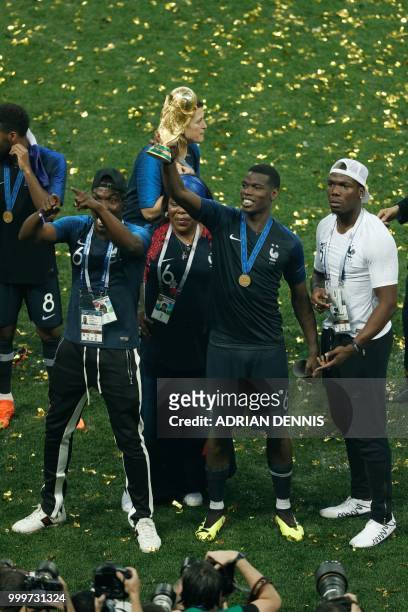 France's midfielder Paul Pogba holds the World Cup trophy after winning the Russia 2018 World Cup final football match between France and Croatia at...