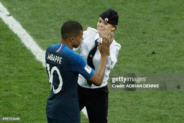 Striker claps in the hand of France's forward Kylian Mbappe on the football pitch during the Russia 2018 World Cup final football match between...