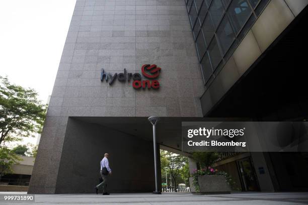 Person walks past the Hydro One Ltd. Headquarters in Toronto, Ontario, Canada, on Thursday, July 12, 2018. Hydro One is facing a long-term share...