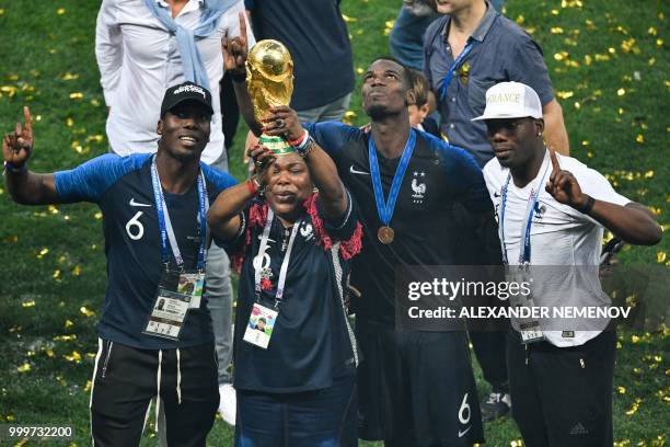 France's midfielder Paul Pogba and his relatives pose with the trophy as they celebrate during the trophy ceremony after winning the Russia 2018...