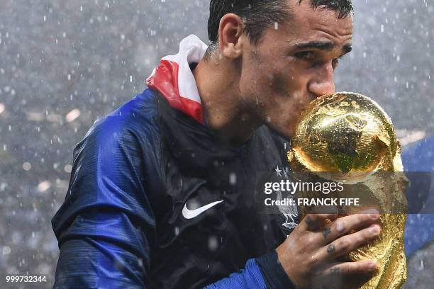 France's forward Antoine Griezmann kisses the World Cup trophy during the trophy ceremony at the end of the Russia 2018 World Cup final football...