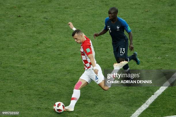 Croatia's forward Ivan Perisic kicks the ball in front of France's midfielder N'Golo Kante during the Russia 2018 World Cup final football match...