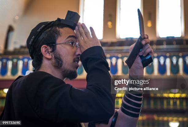 Devoted Jew controls his Tefilin with a mirror at the Westend Synagogue in Frankfurt/Main, Germany, 5 September 2017. Religious jews from different...