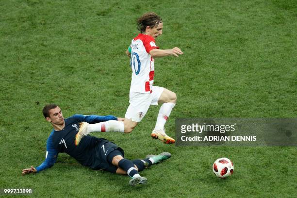 Croatia's midfielder Luka Modric runs past France's forward Antoine Griezmann during the Russia 2018 World Cup final football match between France...