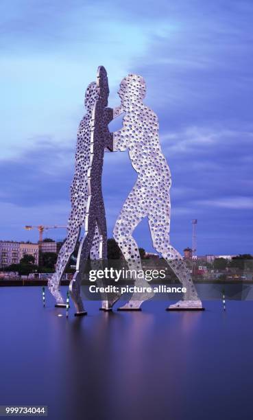 Time exposure shot of the Molecule Man sculpture in the river Spree at dusk in Berlin, Germany, 5 September 2017. Photo: Paul Zinken/dpa