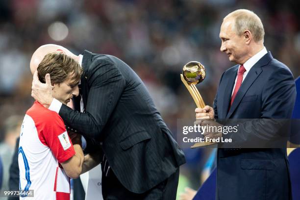 President Gianni Infantino embraces Luka Modric of Croatia as Russia's President Vladimir Putin looks on at the trophy presentation at the end of the...