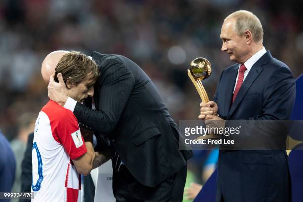President Gianni Infantino embraces Luka Modric of Croatia as Russia's President Vladimir Putin looks on at the trophy presentation at the end of the...