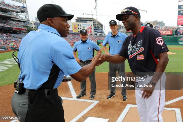 Torii Hunter of Team USA shakes hands with home plate umpire Malachi Moore prior to the SiriusXM All-Star Futures Game at Nationals Park on Sunday,...