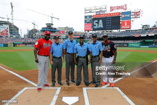 Torii Hunter of Team USA and David Ortiz of the World Team take a photo with the umpiring crew prior to the SiriusXM All-Star Futures Game at...