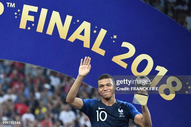 France's forward Kylian Mbappe poses with the FIFA Young Player award during the trophy ceremony at the end of the Russia 2018 World Cup final...
